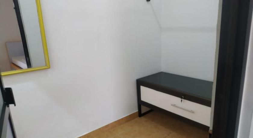 a white bed sitting in a room next to a wall, OYO 90699 Yellow White Guesthouse Palu in Palu
