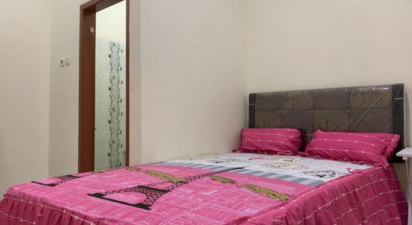 a bed room with a white bedspread and a blue comforter, OYO 90699 Yellow White Guesthouse Palu in Palu