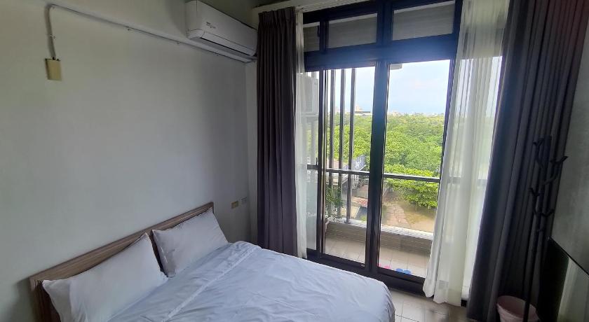 a bedroom with a bed and a window, Green Inn in Yilan