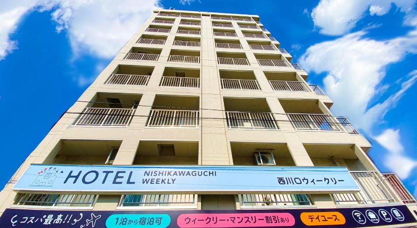 a tall building with a street sign on top of it, Nishikawaguchi Weekly in Kawaguchi
