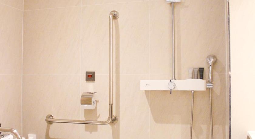 a white toilet sitting next to a shower in a bathroom, Ramada Encore by Wyndham Busan Haeundae in Busan