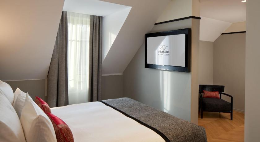 a hotel room with a bed and a television, Fraser Suites le Claridge Champs-Elysees in Paris