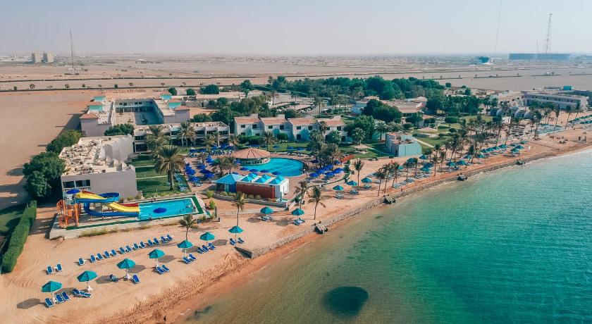 a beach filled with lots of beach chairs and umbrellas, BM Beach Resort in Ras Al Khaimah