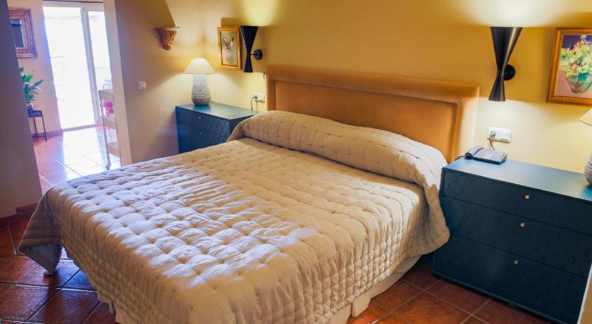 a bedroom with a bed and a dresser, Hotel Carabeo in Nerja