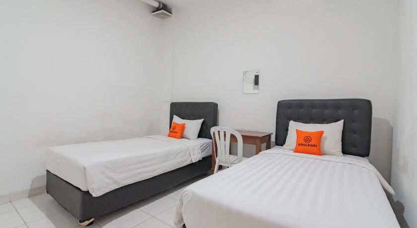 a hotel room with two beds and two lamps, KoolKost near Alun Alun Kota Bandung 2 - Male Only in Bandung