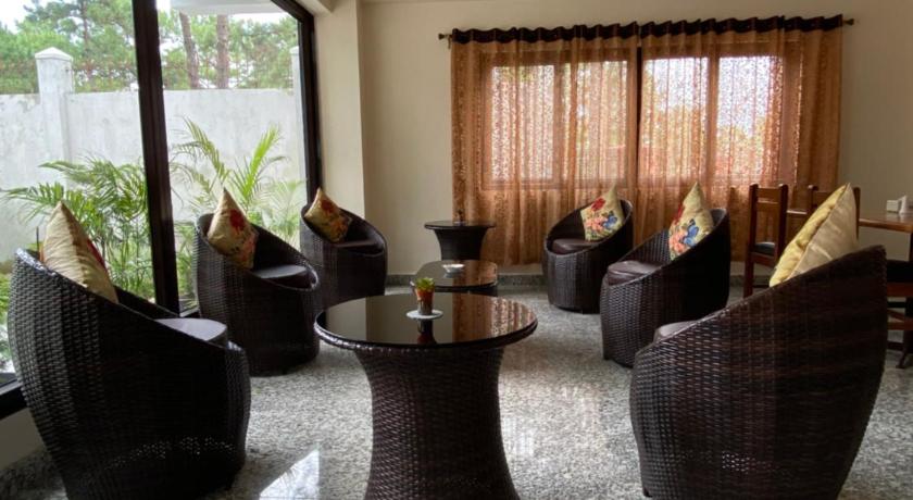 a living room filled with lots of furniture, The Arbour Inn in Shillong