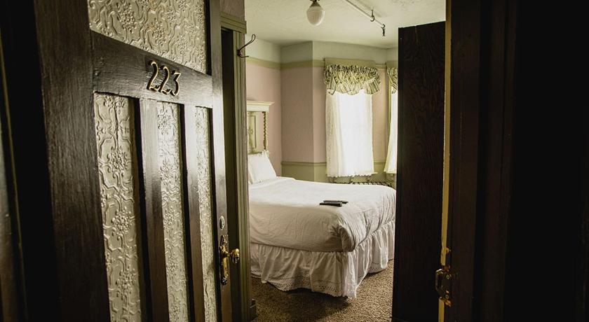 a bedroom with a bed and a mirror, Alaskan Hotel and Bar in Juneau (AK)