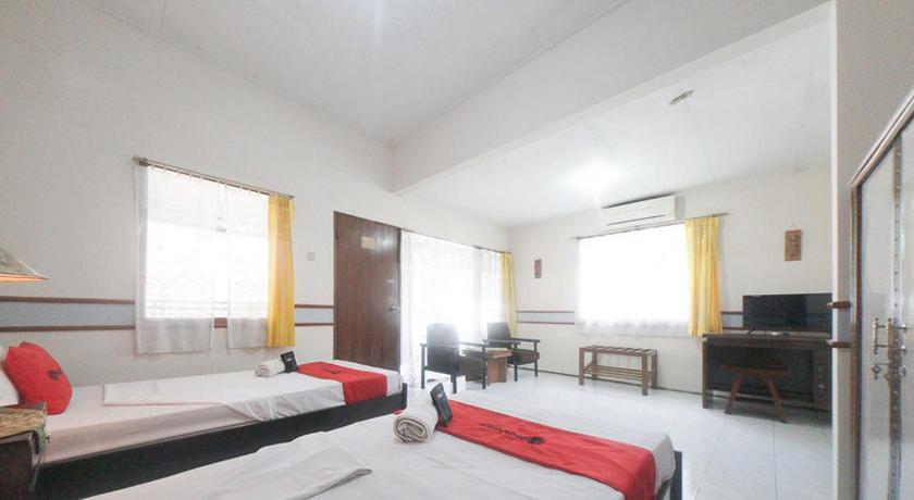 a hotel room with two beds and a television, RedDoorz near Balai Kota Malang in Malang
