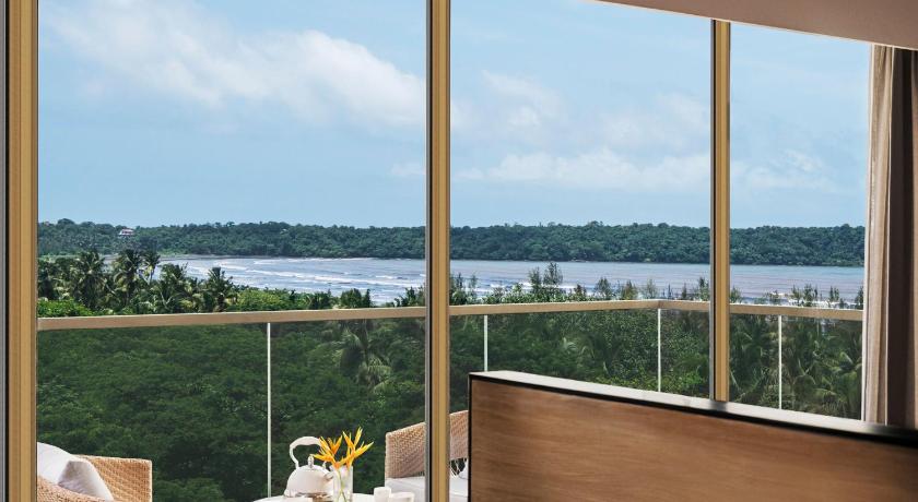 a dining room table with a view of the ocean, Vivanta Goa, Miramar in Goa