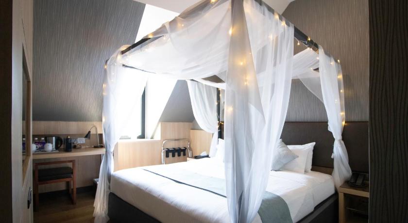 a large bed with a canopy on top of it, Hotel NuVe Stellar in Singapore
