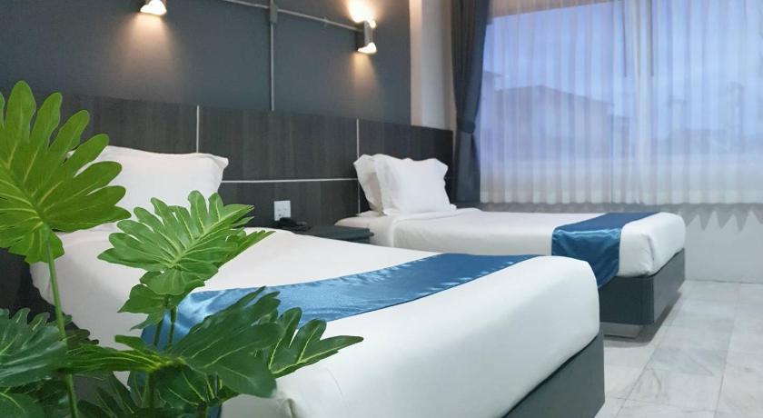 a hotel room with two beds and a large window, The Inka Hotel in Nakhon Si Thammarat