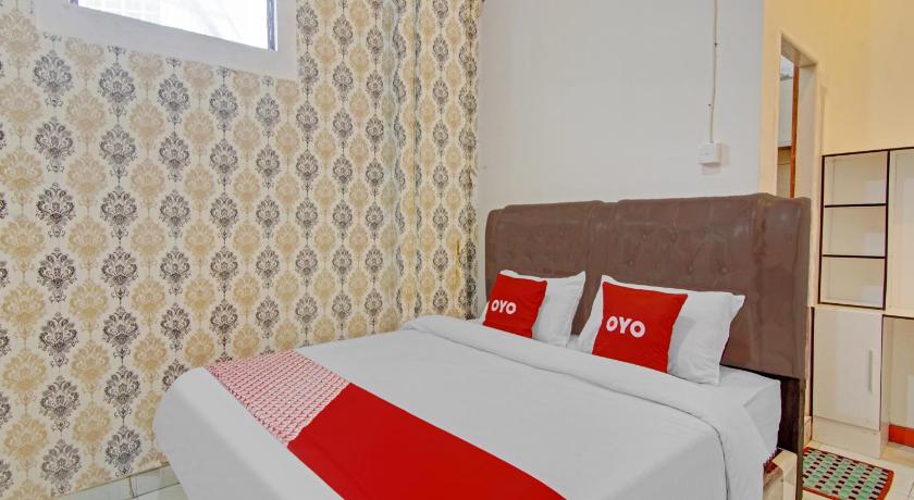 a hotel room with two beds and two lamps, OYO 90615 Jojo Homestay Syariah in Padang