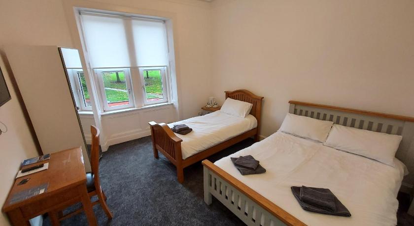 a bedroom with a bed and a desk, Maze Serviced Apartment in Ayr