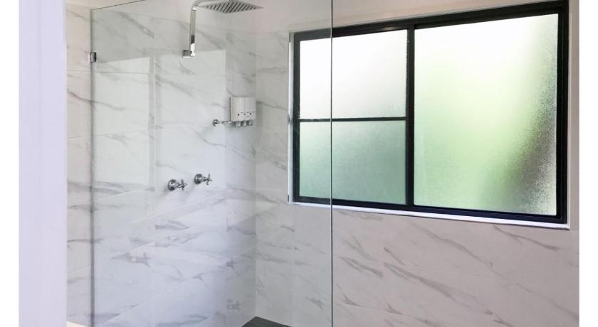 a bathroom with a shower stall and a window, Discovery Parks -Emerald Beach in Coffs Harbour