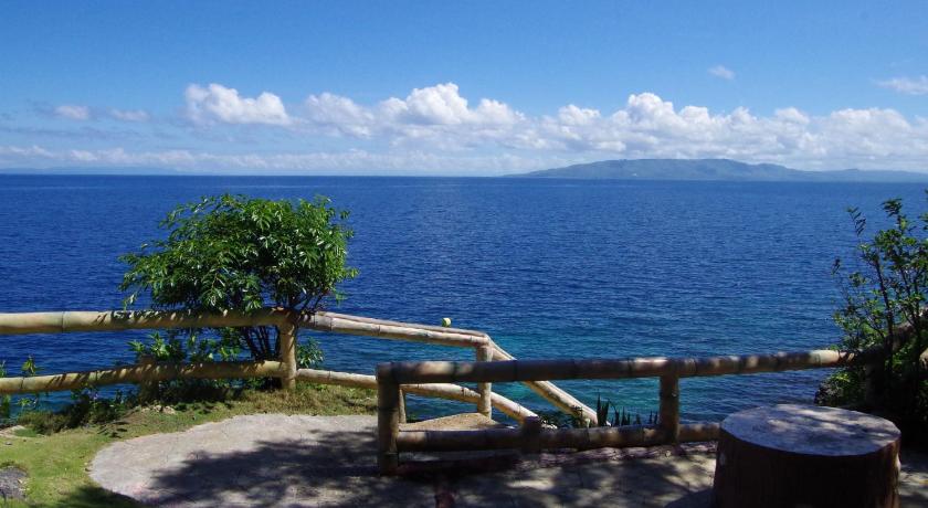 a bench overlooking the ocean with a view of the beach, Almira Diving Resort in Bohol