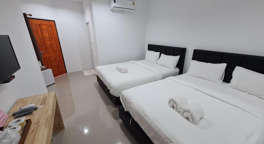 a hotel room with two beds and a television, Vamin Resort Chiangkhan วามินทร์รีสอร์ท เชียงคาน in Chiangkhan