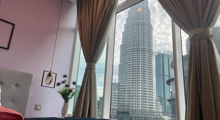 a hotel room with a large window overlooking a city, Sky Suites@KLCC in Kuala Lumpur