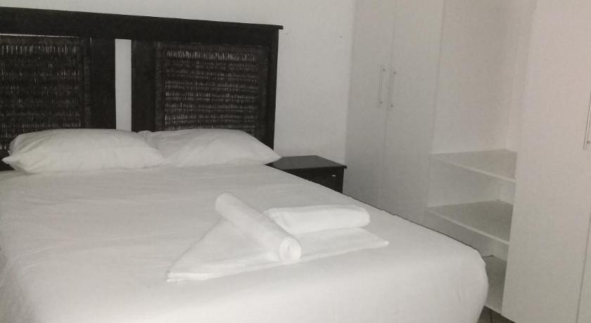a white bed sitting in a room next to a wall, Lisokhanya GuestHouse in East London