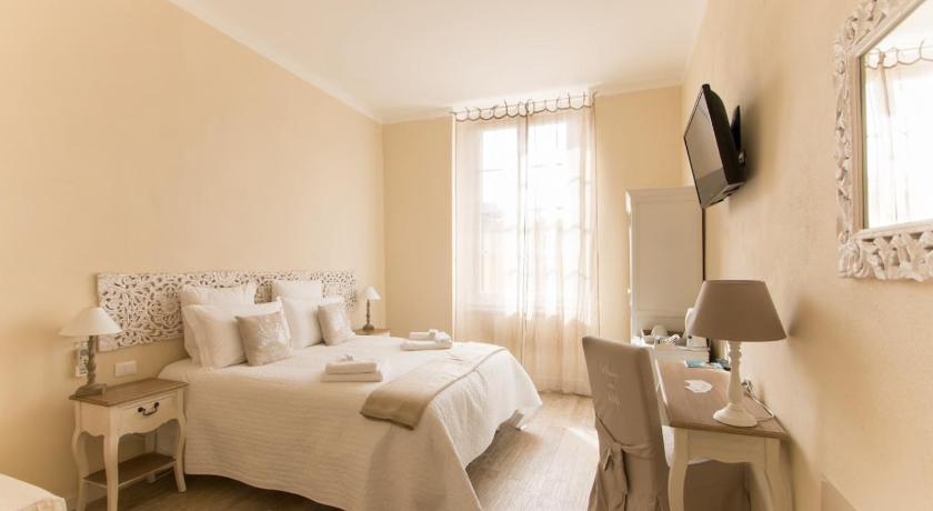 a hotel room with a bed, table and television, Affittacamere Casa Dane in La Spezia