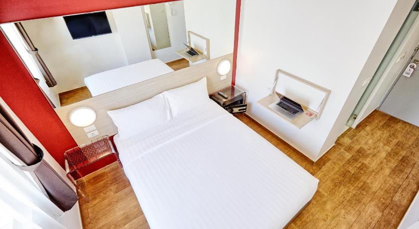 a hotel room with a bed, chair, and nightstand, Red Planet Pattaya (SHA Extra Plus) in Pattaya
