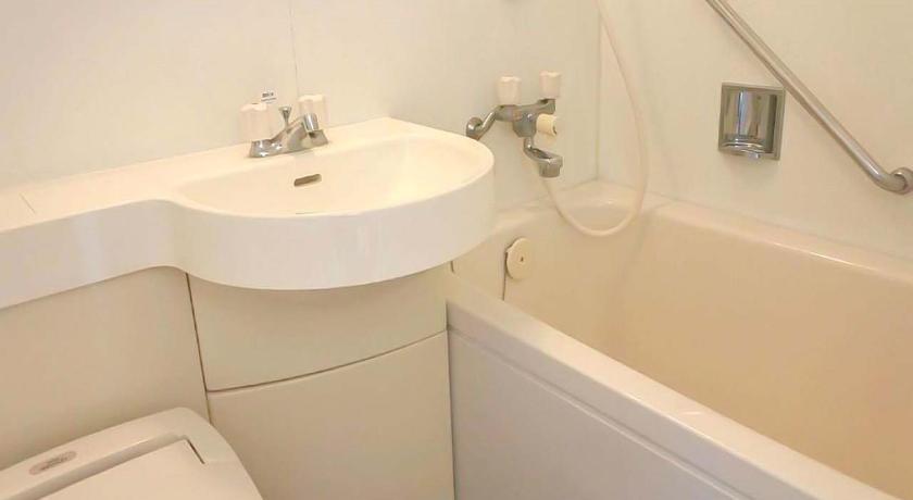 a white toilet sitting next to a bath tub, APA Hotel Miyazaki Nobeoka-Ekimae in Nobeoka