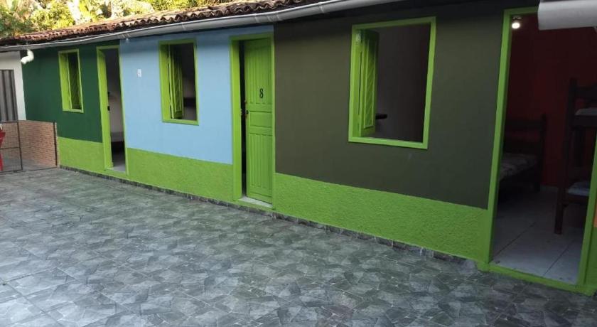 a green and white building with a yellow wall, Hostel Por do Sol - Bahia in Porto Seguro