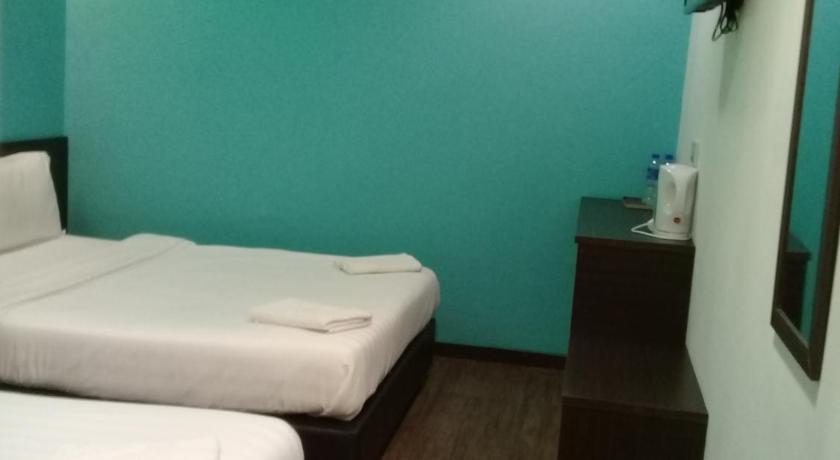 a hotel room with two beds and a desk, Clover Hotel Ipoh in Ipoh