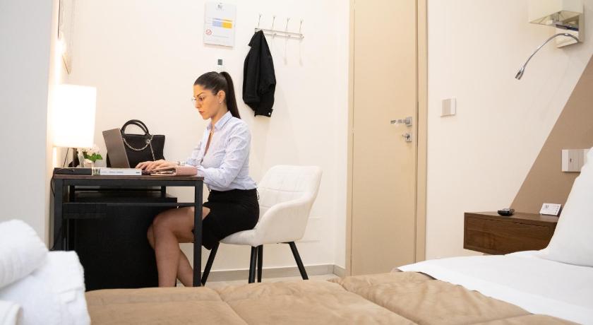 a woman sitting at a desk in a hotel room, B&B De Nava Suite in Reggio Calabria