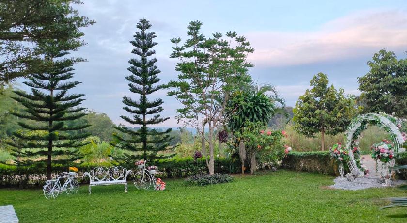 a garden scene with trees and a lawn chair, บ้านเอื้อมดาว เขาค้อ in Khao Kho