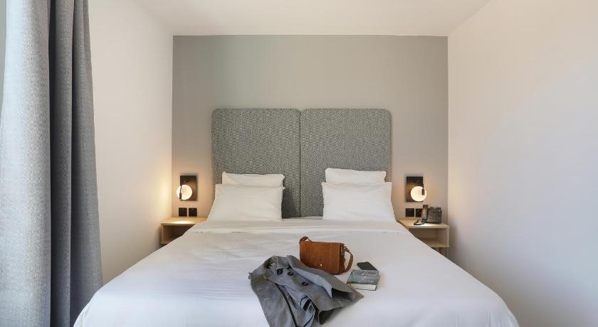 a bed in a hotel room with a white bedspread, Odalys City Toulouse Centre Compans Caffarelli in Toulouse