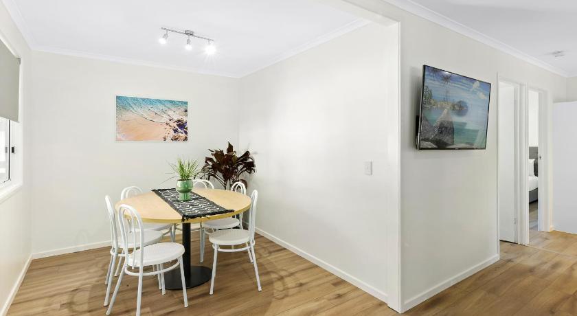 a kitchen with a table, chairs and a refrigerator, Flynns Beach Caravan Park in Port Macquarie