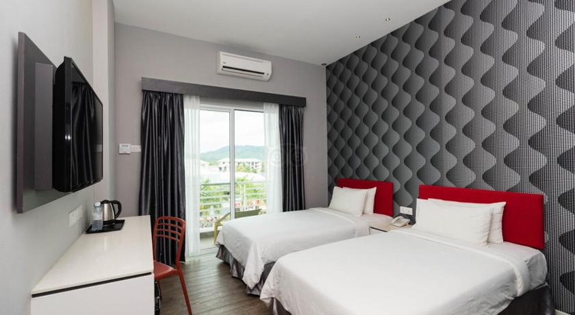 a hotel room with two beds and a television, Cenang Plaza Beach Hotel in Langkawi