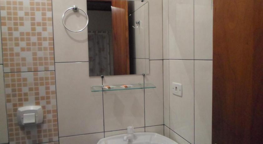 a bathroom with a sink and a mirror, Pousada Laura / Ziza in Foz Do Iguacu