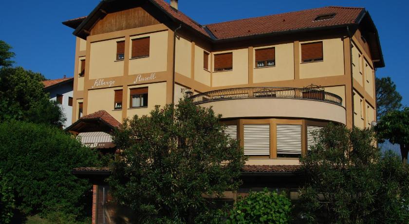 a large white house with a large window, Albergo Rusall in Tremezzo