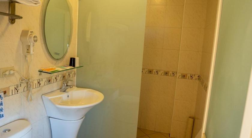 a bathroom with a toilet, sink, and mirror, Cingjing Baiyun Resort in Nantou