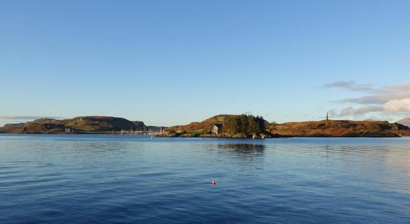 a large body of water with a lighthouse, Oban Youth Hostel in Oban
