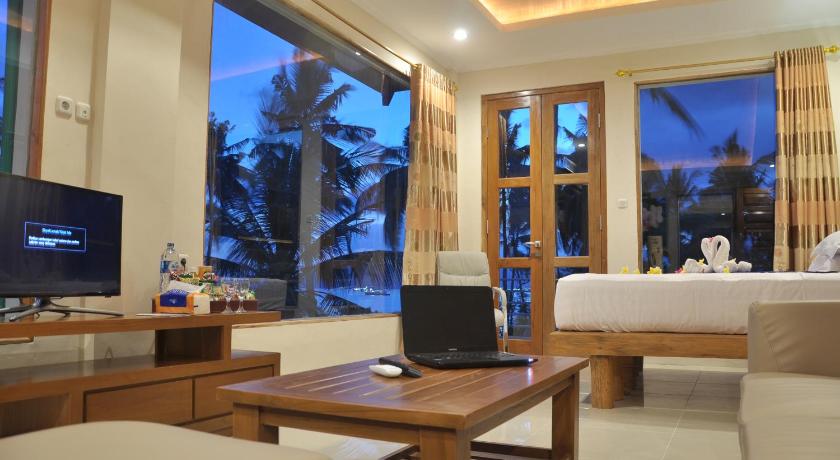 a living room filled with furniture and a tv, Crystal Beach Bali Hotel in Bali