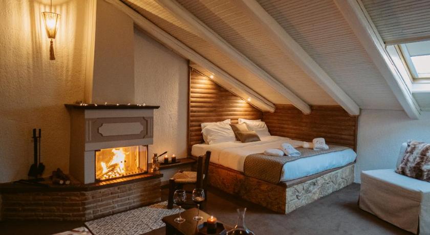 a room with a bed, a chair and a fire place, Afanos Guesthouse in Arachova
