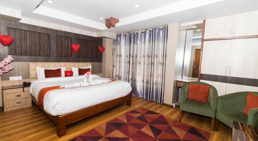 a bedroom with a bed and a dresser, Hotel Marinha Pvt. Ltd. in Kathmandu