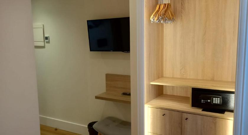 a bedroom with a television and a bed, La Puerta de Nerja Hostal Boutique-Adults Recommended in Nerja