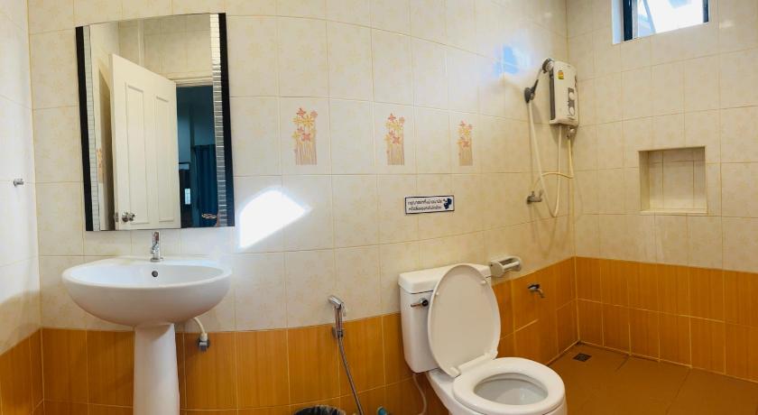a white toilet sitting next to a sink in a bathroom, ช้างเผือกเกสต์เฮ้าส์ in Nan