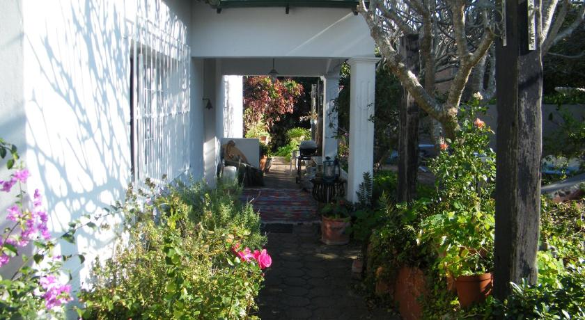 a garden filled with plants next to a building, Valley Guest House in Port Elizabeth