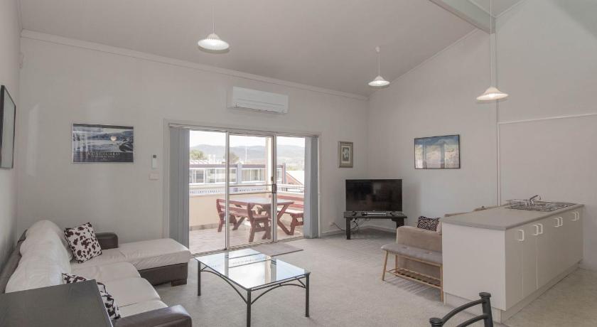 a living room filled with furniture and a table, Razorback 11 in Jindabyne