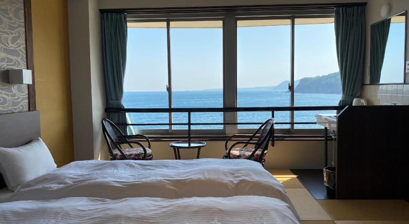 a hotel room with a bed, chair and a window, SPA RESORT RYUGU NO TSUKAI in Izu