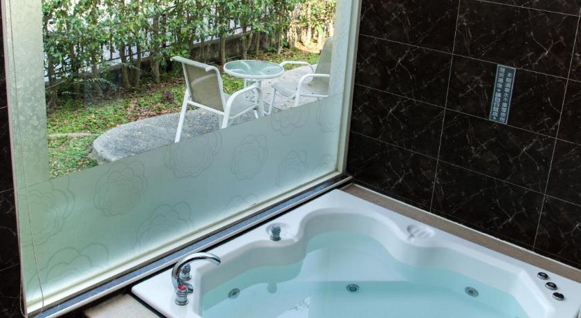 a bath tub sitting in a bathroom next to a window, Guanziling Lin Kuei Yuan Hot Spring Resort in Tainan