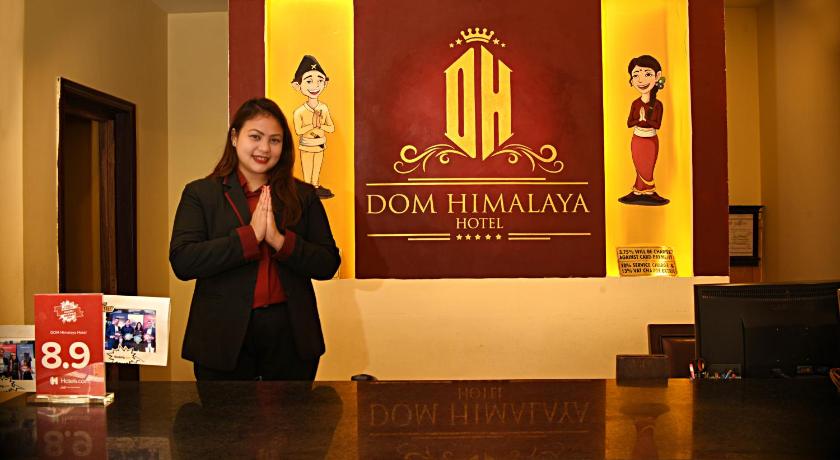 a woman is standing in front of a sign, Dom Himalaya Hotel in Kathmandu
