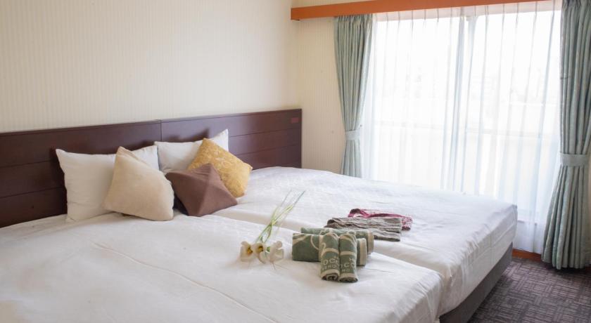 a bed with a white comforter and pillows, Premium Outlet Hotel in Tokyo