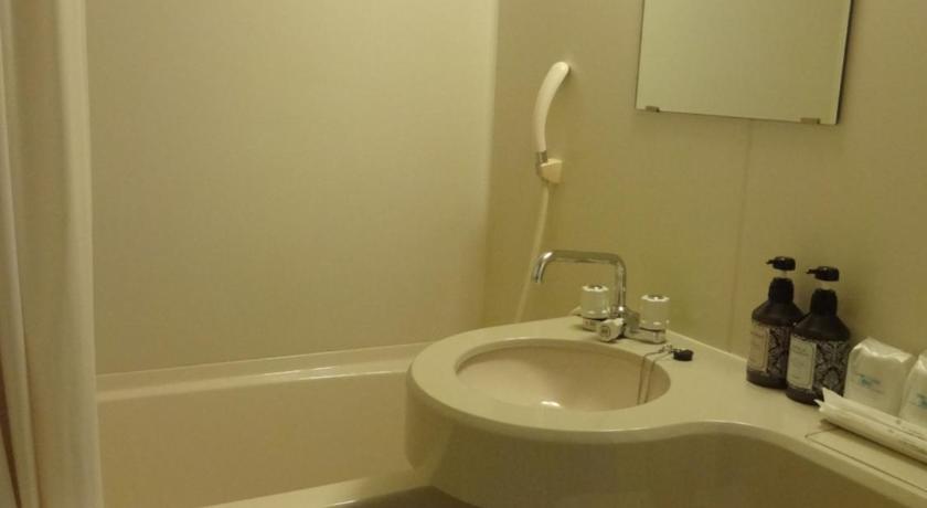 a white toilet sitting next to a sink in a bathroom, Business Hotel Santa in Chikusei