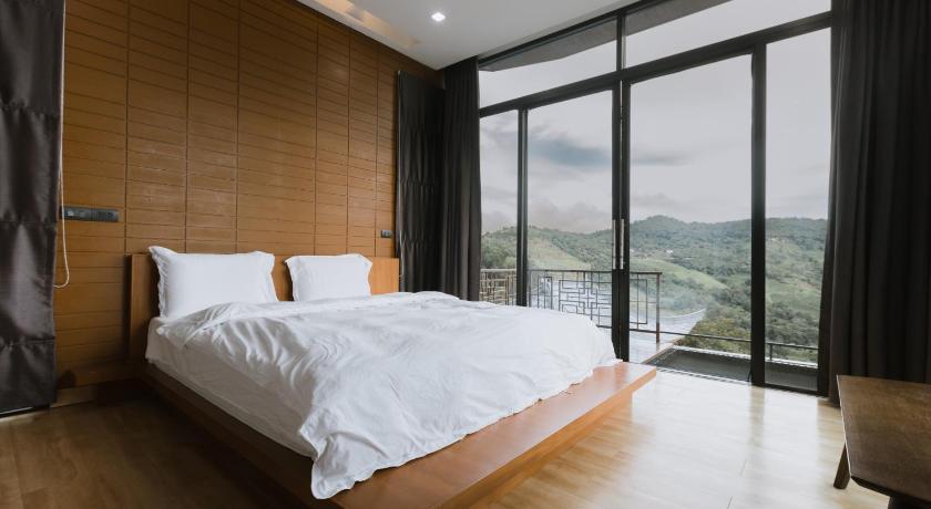 a bedroom with a large bed and a large window, Twins Farm Resort in Mae Salong (Chiang Rai)