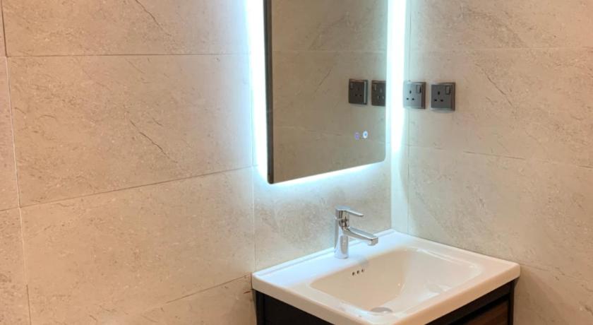 a bathroom with a sink, toilet and mirror, Palms Lily Hotel Suites in Al Ahsa